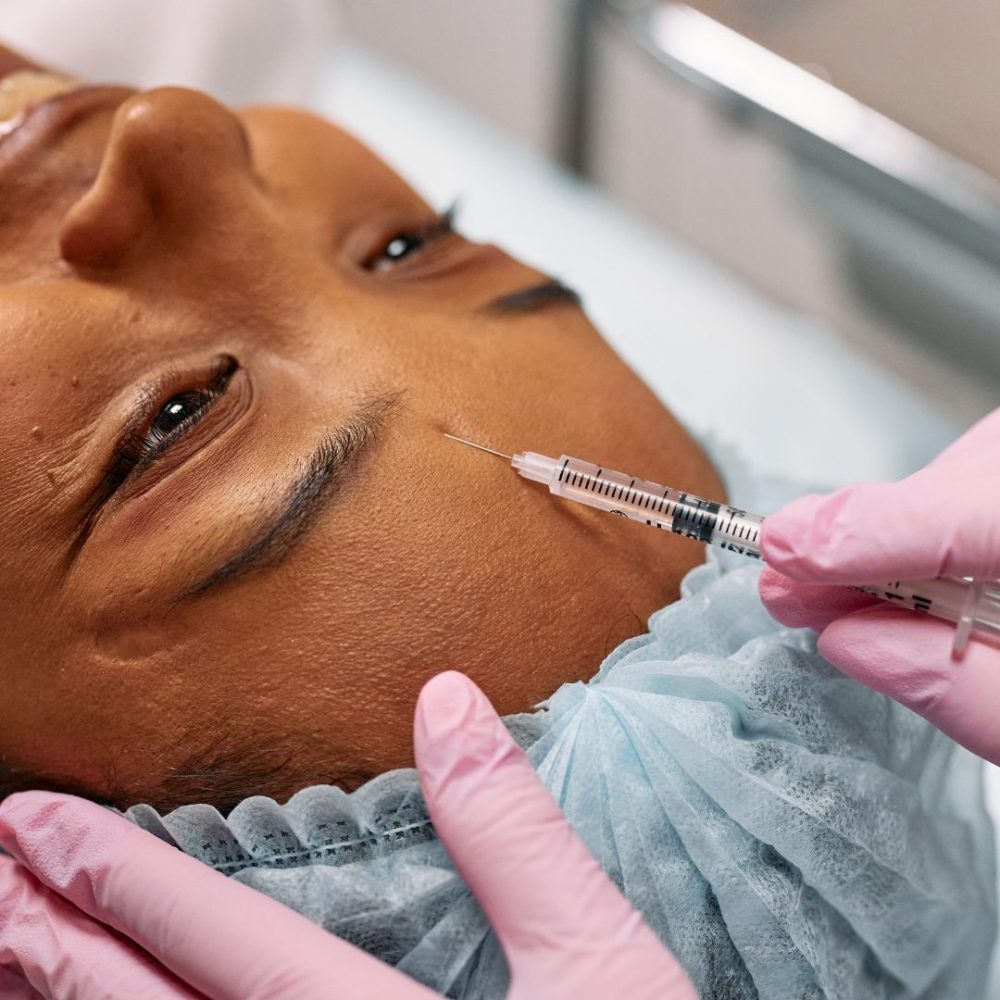 Untitled design Woman Receiving Facial Injection From Pink Gloved Hands